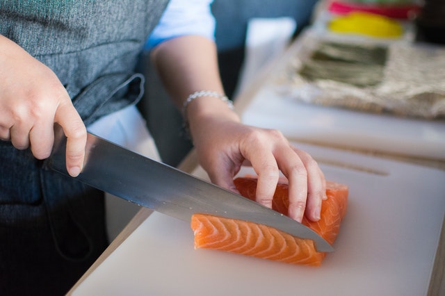 person chopping salmon 